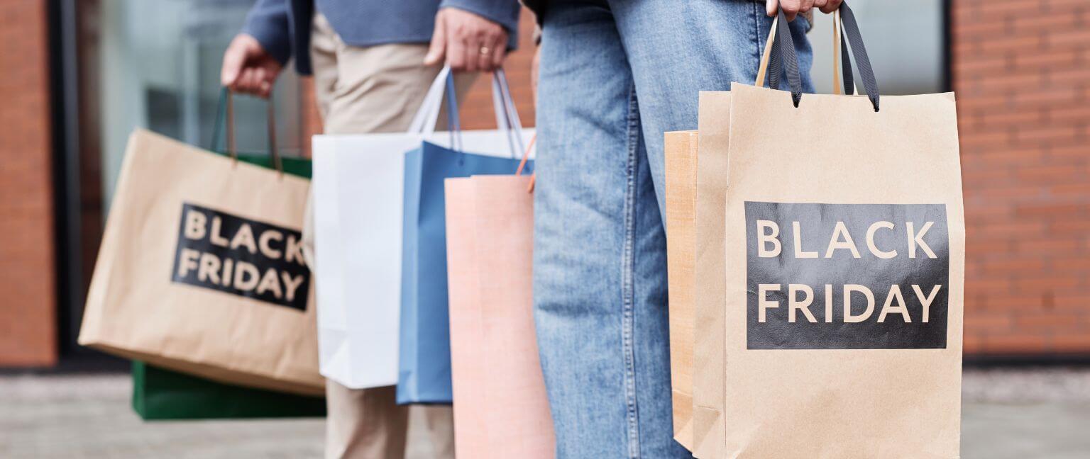 People holding black friday shopping bags